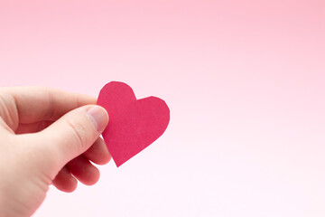 Person holding red heart cards in hands