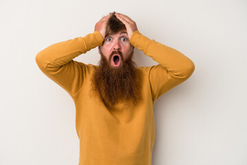 Young caucasian ginger man with long beard isolated on white background surprised and shocked.