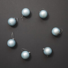 Light blue matte Christmas balls lie in a circle on a dark background. New Year mockup