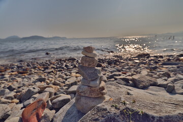a Balanced stones on a pebble beach during sunset.