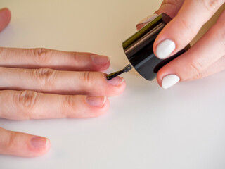 applying a colorless base to the nail. Manicure at home