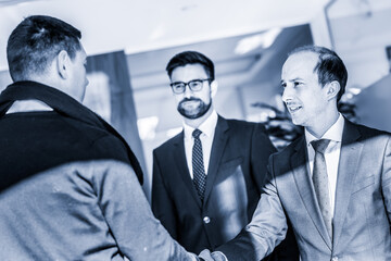 Fototapeta premium Group of confident business people greeting with a handshake at business meeting in modern office or closing the deal agreement by shaking hands.