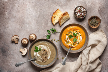 Obraz na płótnie Canvas Mushroom and pumpkin cream soup in a bowl on a brown grunge background. Vegan or vegetarian lunch. Warm winter soup. Top view, flat lay.