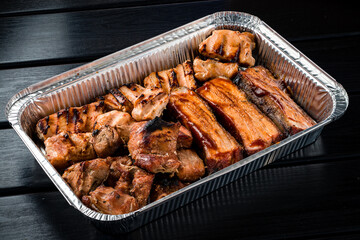 set of grilled ribs and BBQ meat in a delivery box