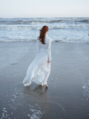 Fototapeta na wymiar Woman in white dress beach ocean walk fresh air