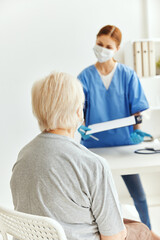 Obraz na płótnie Canvas elderly woman and doctor professional examination medical masks