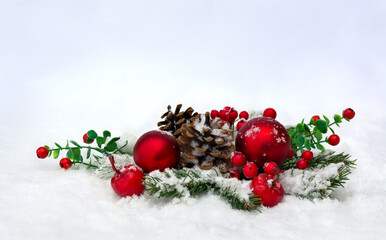 Fototapeta na wymiar Christmas decoration. Cone pine, twigs christmas tree, red berries, red balls, apples on snow with space for text