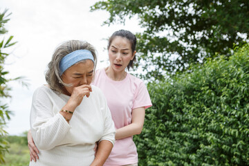 asian young daughter caring for sick senior mother To suffering illness or cough at home . old mom...