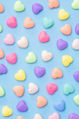 Pattern of colorful heart candies on a blue background creative concept background