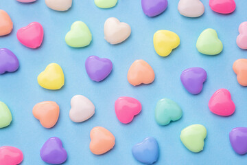 Pattern of colorful heart candies on a blue background creative concept background