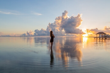 Woman in the sea at sunrise
