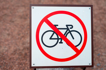 Sign of no bikes on a fence near house.