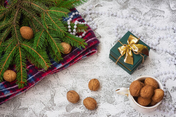 Fototapeta na wymiar New Year's or Christmas composition of spruce green branches, red plaid, walnuts, gift and Christmas lollipops