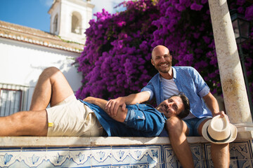 Happy gay couple having romantic time together.Two men in casual clothes relaxing in villa, partner...