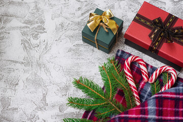 New Year's or Christmas composition of spruce green branches, plaid, New Year's gift and Christmas lollipops