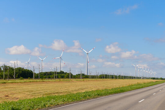 wind turbine poles along the highway on a sunny summer day