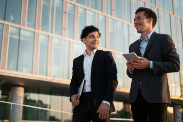 Entrepreneurs work near the office. Portrait of bankers in suits talking. Financiers go to work together. Lawyers communicate with each other.