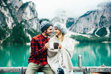 Portrait of a romantic couple of adults visiting an alpine lake at Braies Italy at winter - Tourist...