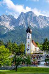 Sankt Johannes der Täufer Kirche mit Alpen im Hintergrund, Grainau, Deutschland 