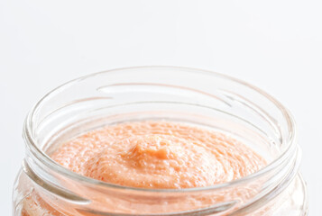 Pollock fish roe mixed with mayonnaise in an open glass jar. Macro. White background. Selective...