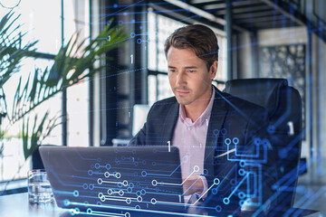Handsome businessman in suit at workplace working with laptop to optimize development by implying...