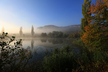 Beautiful foggy morning in autumn in the mountains by the lake