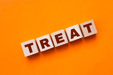 Obraz premium The hand puts a wooden cube with the letter T from the word TREND. The word is written on wooden cubes standing on the yellow surface of the table. Concept.