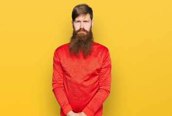 Redhead man with long beard wearing casual clothes skeptic and nervous, frowning upset because of...