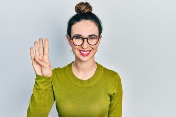 Young hispanic girl wearing casual clothes and glasses showing and pointing up with fingers number four while smiling confident and happy.