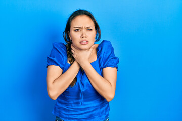 Young hispanic girl wearing casual clothes shouting and suffocate because painful strangle. health problem. asphyxiate and suicide concept.