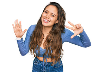 Young hispanic girl wearing casual clothes showing and pointing up with fingers number eight while smiling confident and happy.