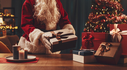 Santa Claus putting Christmas gifts on a table