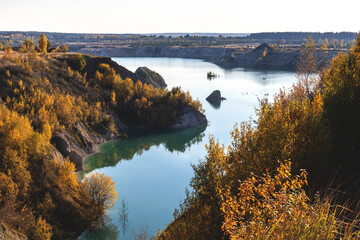 Beautiful autumn landscape with different colors of nature at the top of a chalk quarry with a turquoise lake