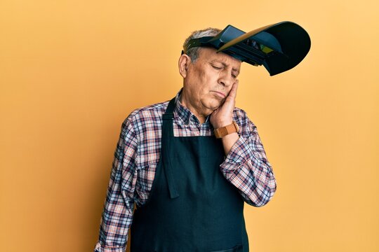 Handsome Senior Man With Grey Hair Wearing Welding Protection Mask Thinking Looking Tired And Bored With Depression Problems With Crossed Arms.