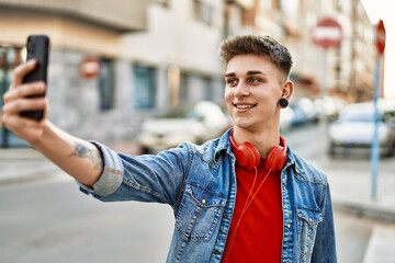 Young caucasian guy smiling taking a selfie picture at the city