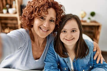 Mature mother and down syndrome daughter at home taking a picture