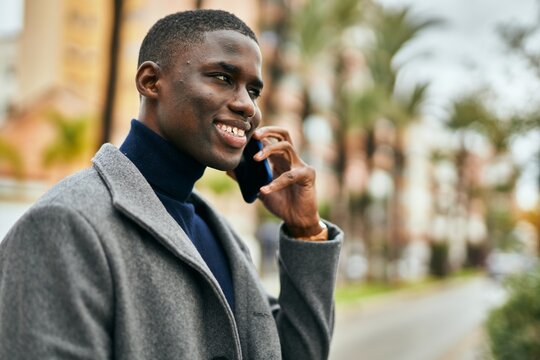Young african american man smiling happy talking on the smartphone at the city