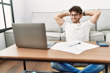 Fototapeta premium Young hispanic man smiling confident studying at home