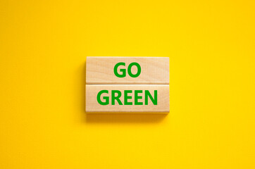 Time to go green ecology symbol. Concept words Go green on wooden blocks on a beautiful yellow background. Business, ecology and go green concept. Copy space.