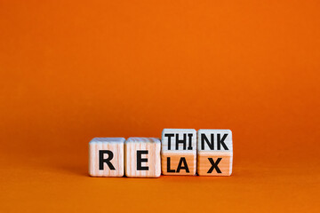 Obraz premium Relax and rethink symbol. Businessman turned cubes and changed the word 'relax' to 'rethink'. Beautiful orange table, orange background. Business, relax and rethink concept. Copy space.