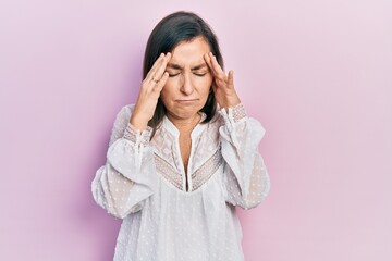 Middle age hispanic woman wearing casual clothes with hand on head for pain in head because stress. suffering migraine.