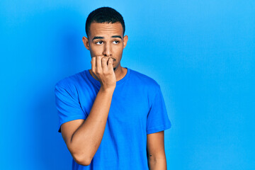 Young african american man wearing casual blue t shirt looking stressed and nervous with hands on...