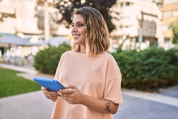 Obraz premium Young hispanic woman smiling confident using touchpad at park