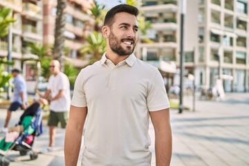 Young hispanic man smiling confident walking at street