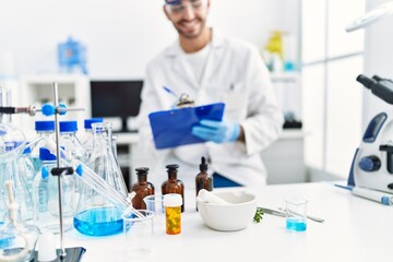 Fototapeta premium Handsome hispanic man working as scientific at laboratory