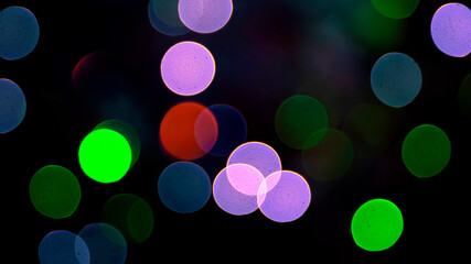 Colored blurred bokeh. abstract background of included festive garlands. colorful blur light bulbs