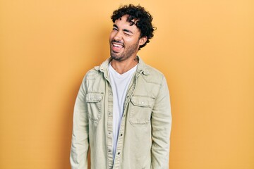 Young hispanic man wearing casual clothes winking looking at the camera with sexy expression, cheerful and happy face.