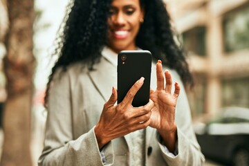 Middle age african american businesswoman using smartphone at the city.