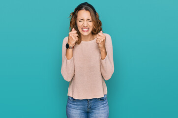 Fototapeta premium Beautiful young caucasian woman wearing casual sweater excited for success with arms raised and eyes closed celebrating victory smiling. winner concept.
