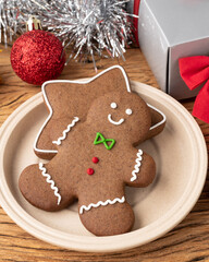Traditional christmas gingerbread cookies over a wooden table with gift box and christmas decoration
